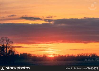 Countryside sunset with a beautiful horizon and dramatic clouds over farmland