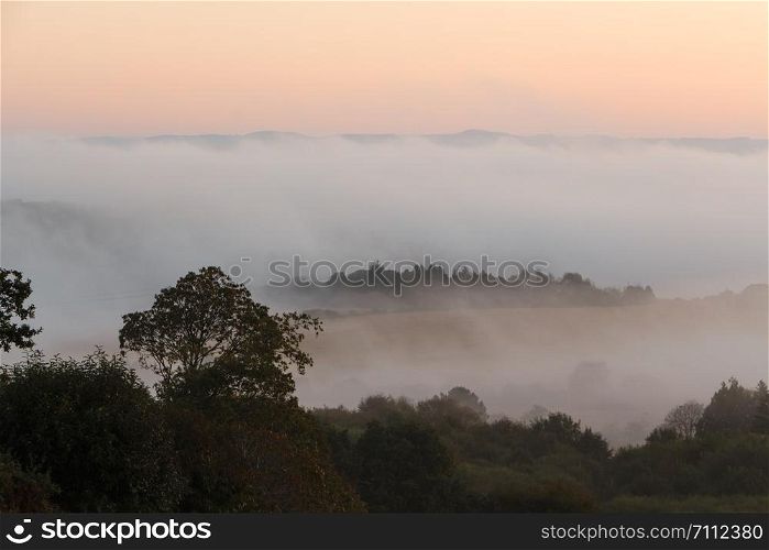 Countryside under the fog in Brittany during sunrise