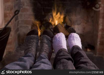 Couple&acute;s feet warming at a fireplace