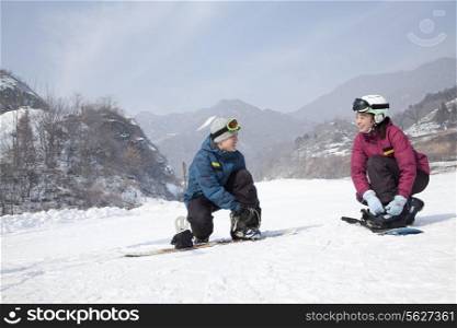Couple adjusting Ski Boots in Ski Resort