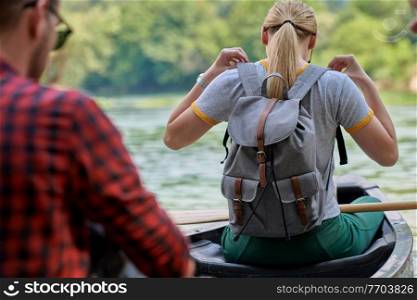 Couple adventurous explorer friends are canoeing in a wild river surrounded by the beautiful nature