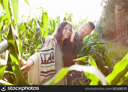 Couple amongst corn plants in field