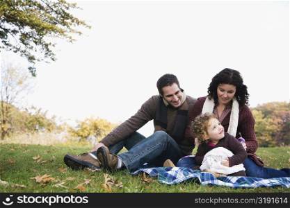 Couple and their daughter sitting together and smiling