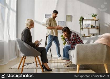 Couple arguing with each other on therapy session. Discussion relationship with marriage counselor. Couple arguing each other on therapy session