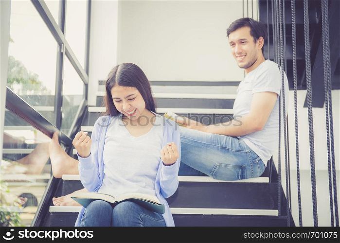 Couple asian handsome man and beautiful woman reading book and smile at home, boyfriend and girlfriend glad with activities together for leisure, education success concept.