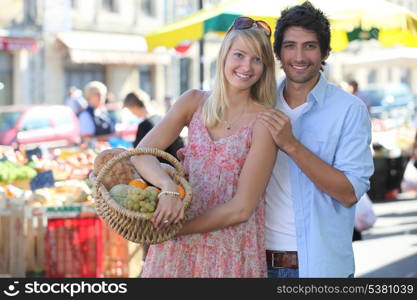 Couple at a market with basket of produce