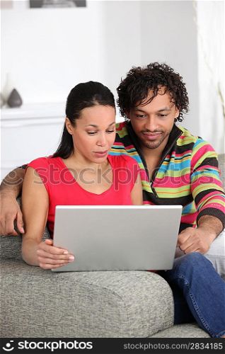 Couple at home looking at a laptop