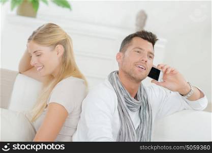 Couple at home, man on cellphone