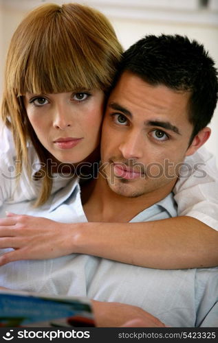 Couple at home reading newspaper