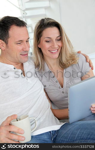 Couple at home using electronic tablet