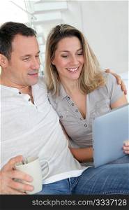 Couple at home using electronic tablet
