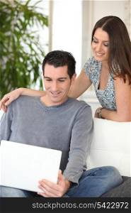 Couple at home watching laptop screen