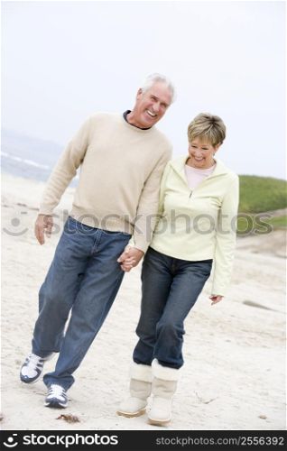 Couple at the beach holding hands and smiling