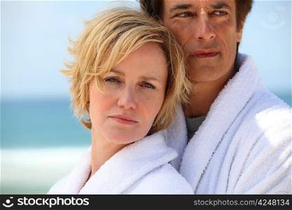Couple at the beach wearing dressing gowns