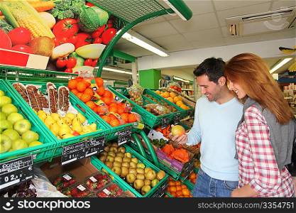 Couple at the supermarket doing grocery shopping