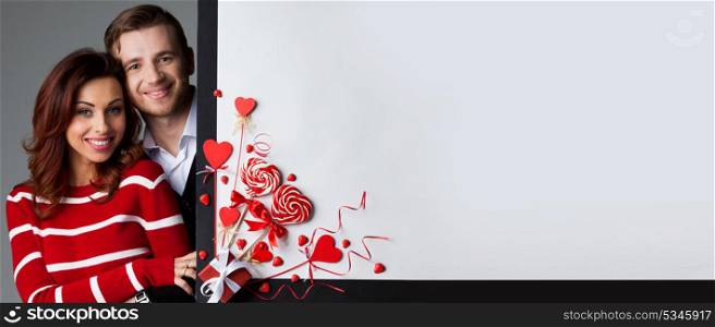 Couple at Valentine&rsquo;s day. Happy couple posing with Valentine&rsquo;s day decoration with white copy space