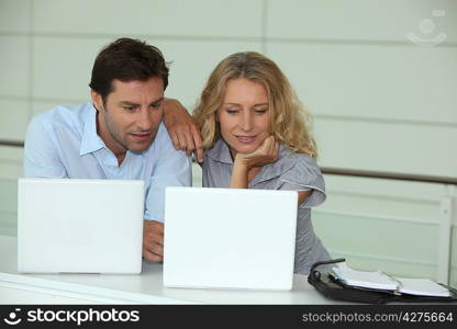 Couple at work on laptops
