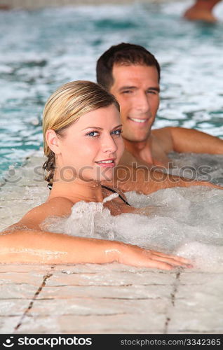 Couple bathing in jacuzzi of spa center