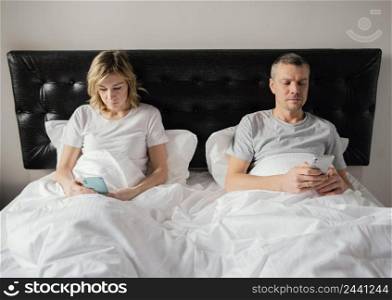 couple bed using mobiles