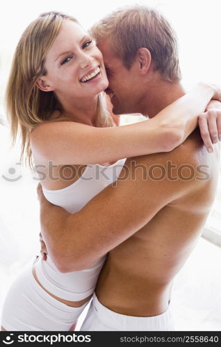 Couple bedroom embracing and smiling