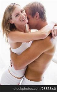 Couple bedroom embracing and smiling