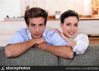 Couple behind sofa