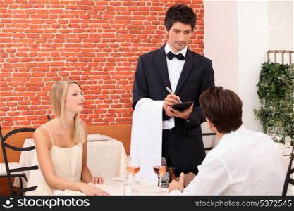 Couple being served by a waiter