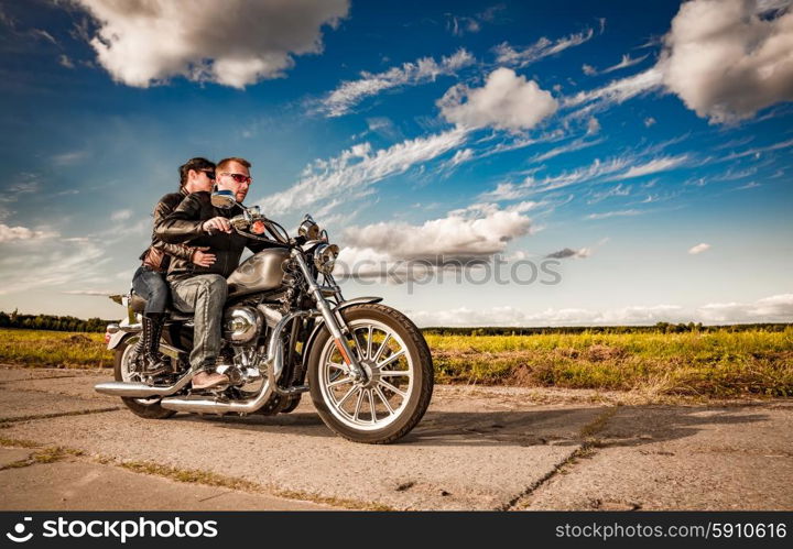 Couple Bikers in a leather jacket riding a motorcycle on the road