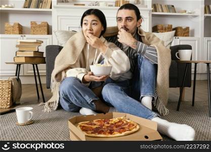 couple blanket eating pizza popcorn