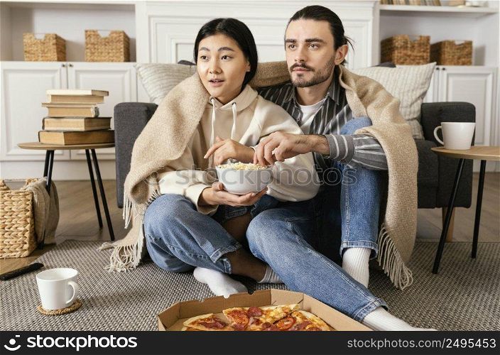 couple blanket watching movie eating