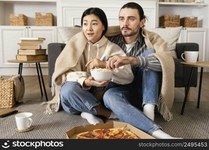 couple blanket watching movie eating