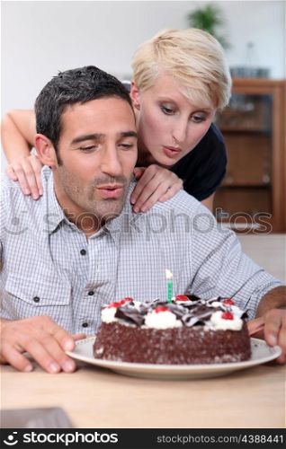 Couple blowing candle