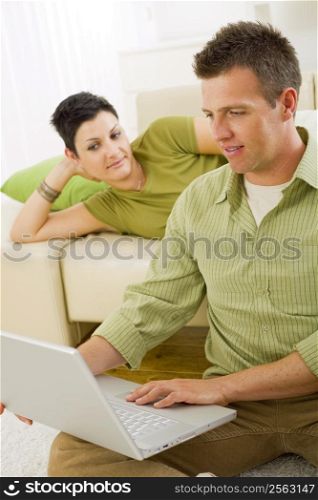 Couple browsing internet on laptop on laptop computer at home.