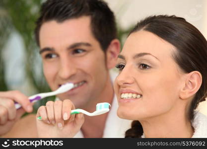 Couple brushing their teeth