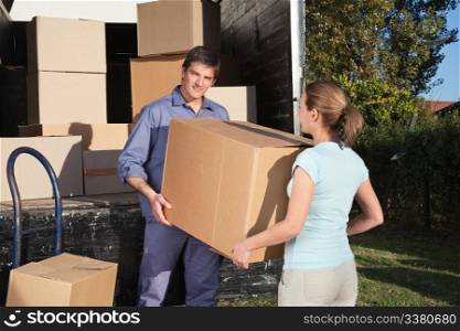 Couple carrying box into the truck while moving into new home