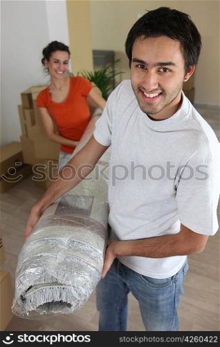 Couple carrying carpet