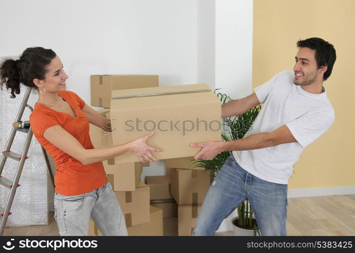 Couple carrying moving boxes