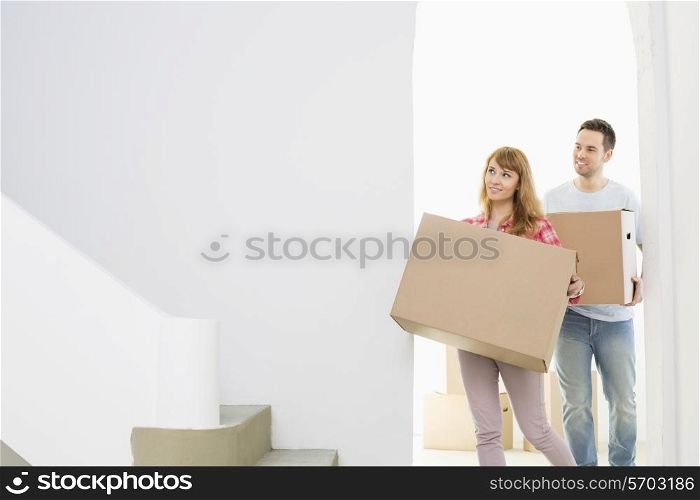 Couple carrying moving boxes