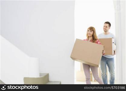 Couple carrying moving boxes