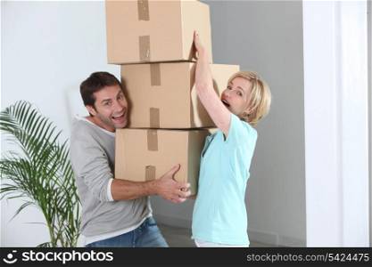 Couple carrying pile of boxes