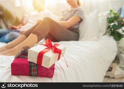 Couple celebrating date in modern room. Christmas, new Year,valentine day or birthday concept. Beautiful gift box and blurred couple on background. Copy space for text.