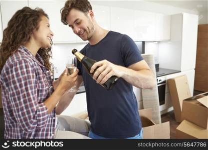 Couple Celebrating Moving Into New Home With Champagne