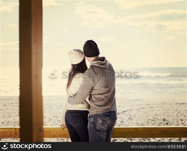 Couple chating and having fun at beach bar. Happy couple enyojing time together on beach during autumn day colored filter