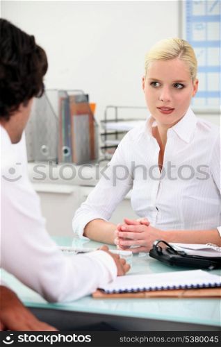 Couple chatting over an office desk