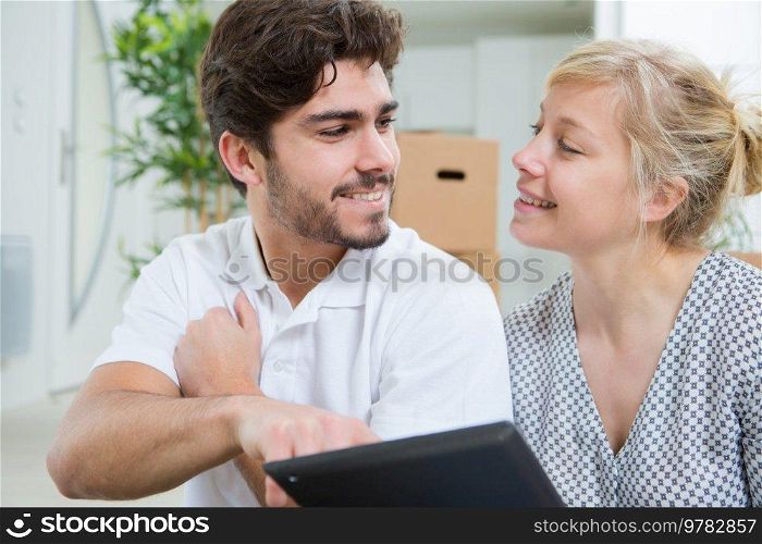 couple chilling with digital tablet
