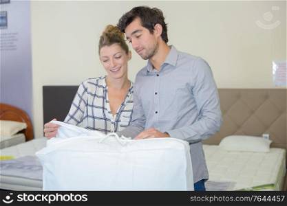 couple choosing duvet in a bedding store