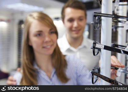 Couple Choosing Glasses In Opticians