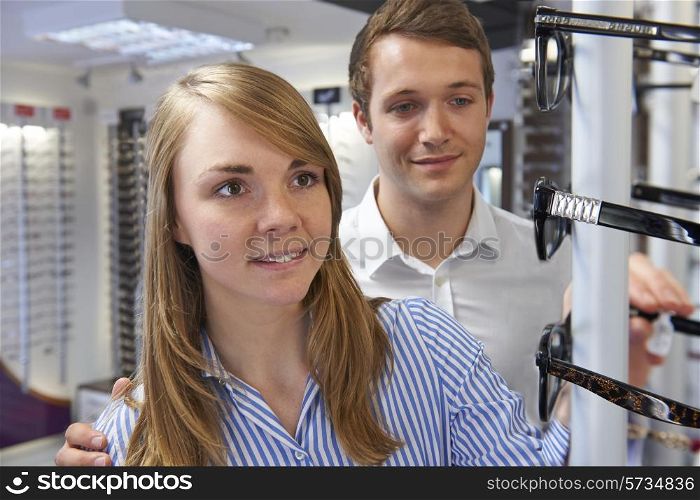 Couple Choosing Glasses In Opticians