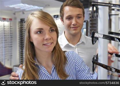 Couple Choosing Glasses In Opticians