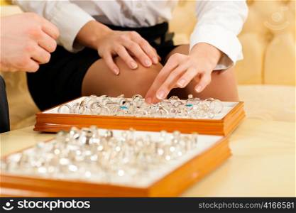 Couple choosing wedding rings at a jeweller